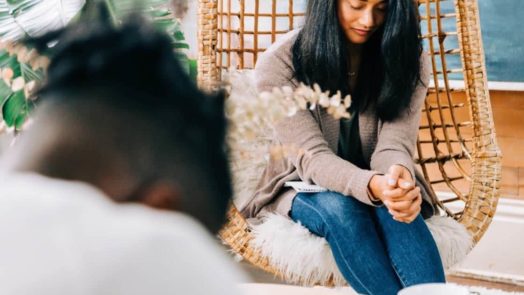 man and woman praying together in living room